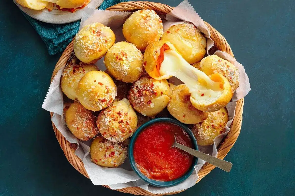 K&ouml;stliche K&auml;se-B&auml;llchen, perfekt, um &uuml;brig gebliebenen **Pizzateig zu verwerten**. Mit Chili und Parmesan bestreut, serviert mit Dip.