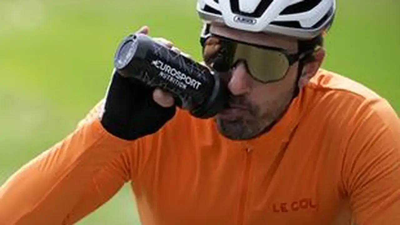 Radfahrer trinkt aus Flasche bei einem italienischen Radsportereignis.