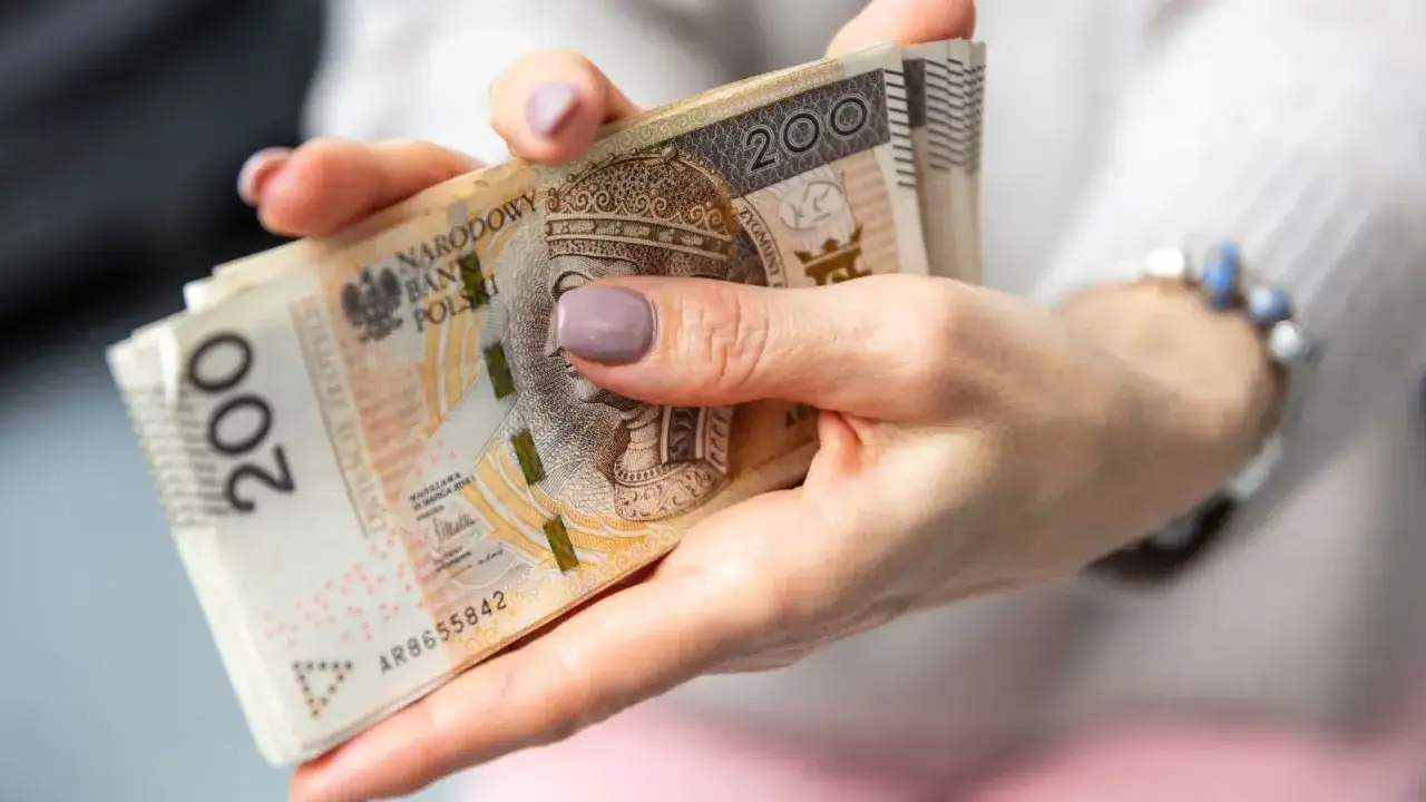 Dłonie trzymające plik banknot&oacute;w 200 zł. Pytanie: czy można pracować na rencie z całkowitą niezdolnością do pracy?