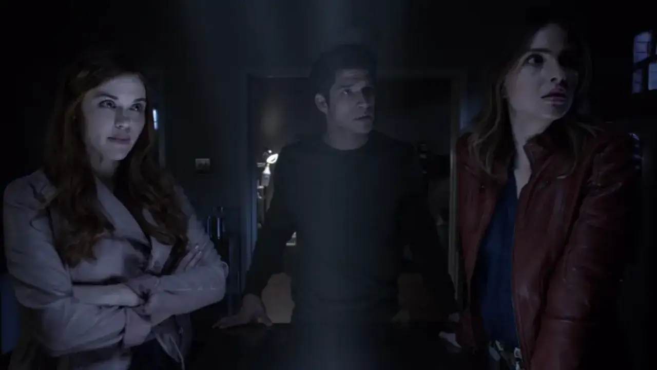 Obsada Teen Wolf: Scott, Lydia i Malia w mrocznym pomieszczeniu, wyglądają na zaniepokojonych.