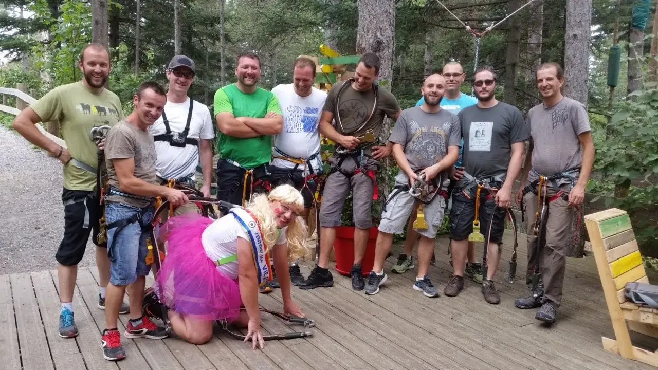 Groupe d'amis en tenue d'**activité EVG** dans un parc aventure, prêts pour le fun !
