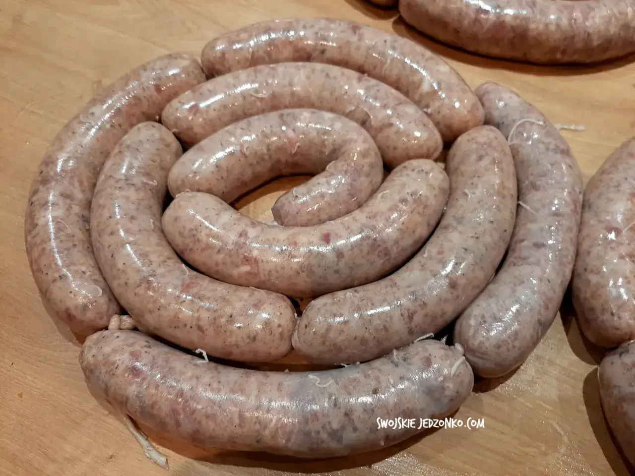 Biała kiełbasa ułożona w okrąg. Zastanawiasz się, ile soli do białej kiełbasy? Ta wygląda idealnie doprawiona.