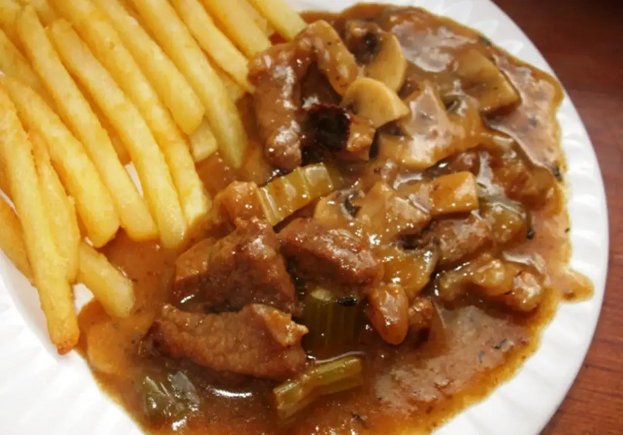 Pyszna wołowina w sosie z pieczarkami i selerem, podana z chrupiącymi frytkami. Idealny obiad!