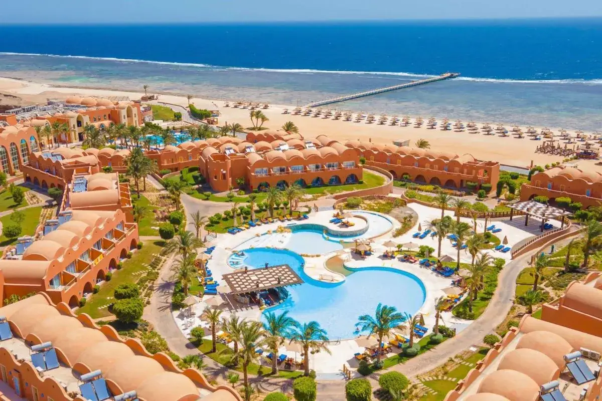 Widok z lotu ptaka na kompleks hotelowy Novotel Marsa Alam z basenami, palmami i plażą. Idealne miejsce na wakacje, zgodnie z wieloma pozytywnymi **novotel marsa alam opinie**.