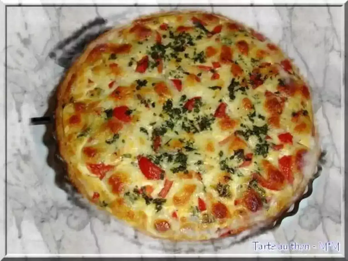 Tarte au thon dorée et appétissante, parfaite pour une recette tarte au thon facile et rapide. Garnie de dés de tomates et d'herbes.