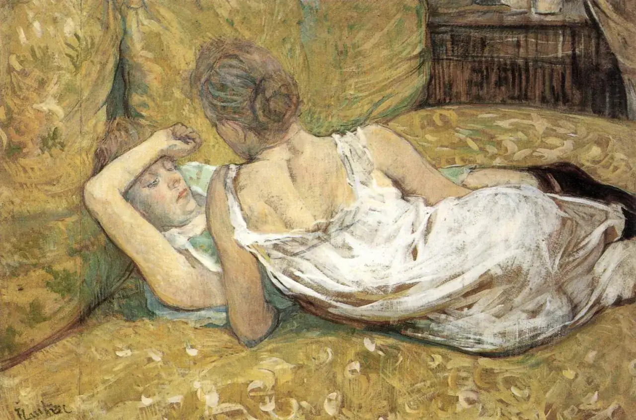 Two women share an intimate moment, one resting her head on the other's shoulder in bed. A tender kiss is exchanged between them.