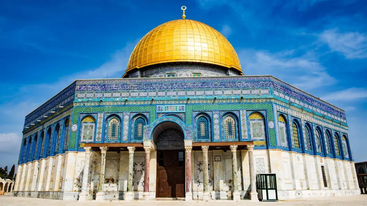 The Dome of the Rock, a stunning example of Islamic architecture, stands today as a testament to history. Its golden dome gleams under a bright blue sky.