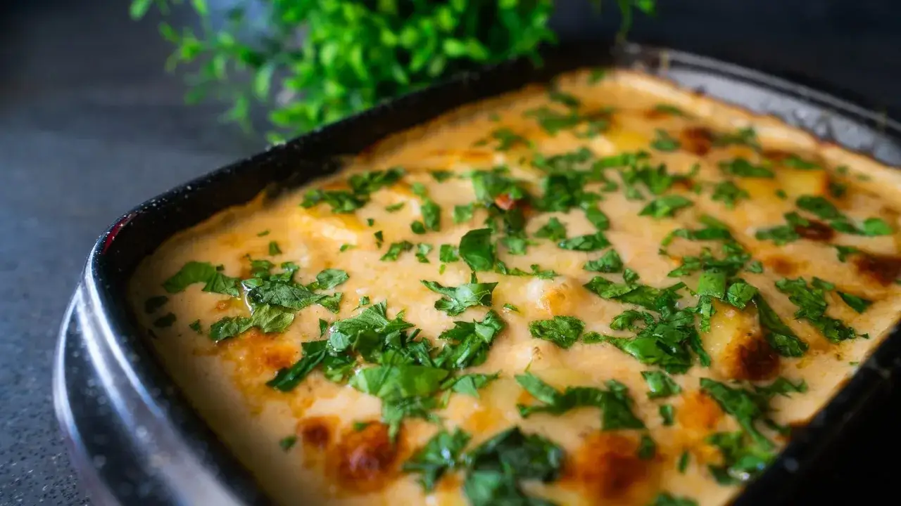 Cremiges Kartoffelgratin, frisch aus dem Ofen, mit Petersilie bestreut. Ein köstliches Rezept für jeden Anlass.