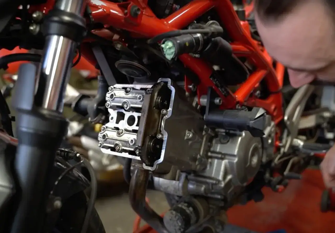 Mechanik sprawdza zawory motocykla. Za mały luz zaworowy objawy mogą być trudne do zdiagnozowania, ale ten widok silnika jest kluczowy.