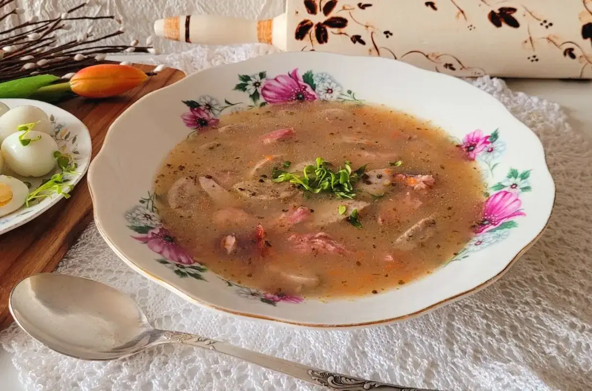 Aromatyczna zupa na wędzonce, podana w ozdobnej misce, z jajkami na boku.