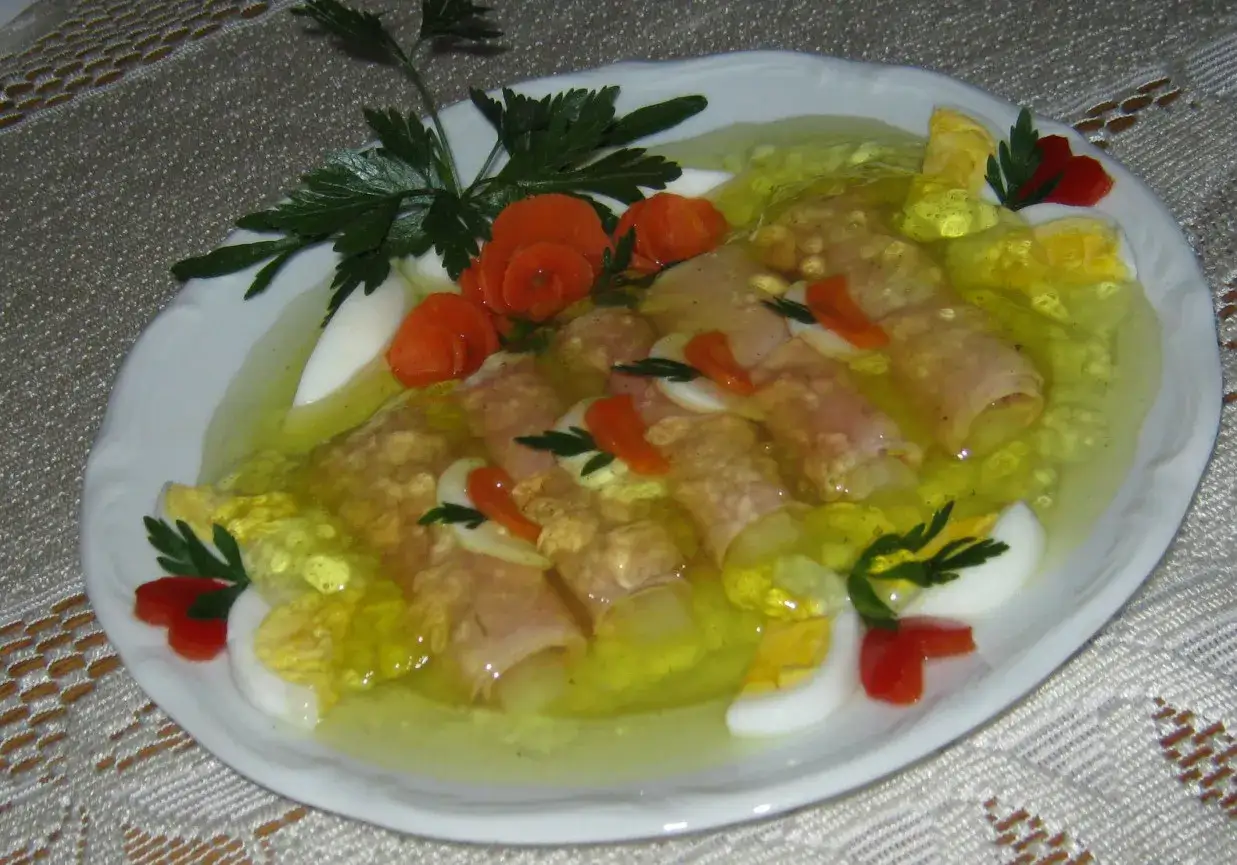Eleganckie szparagi w galarecie, ozdobione jajkiem, marchewką i natką pietruszki, prezentują się apetycznie.