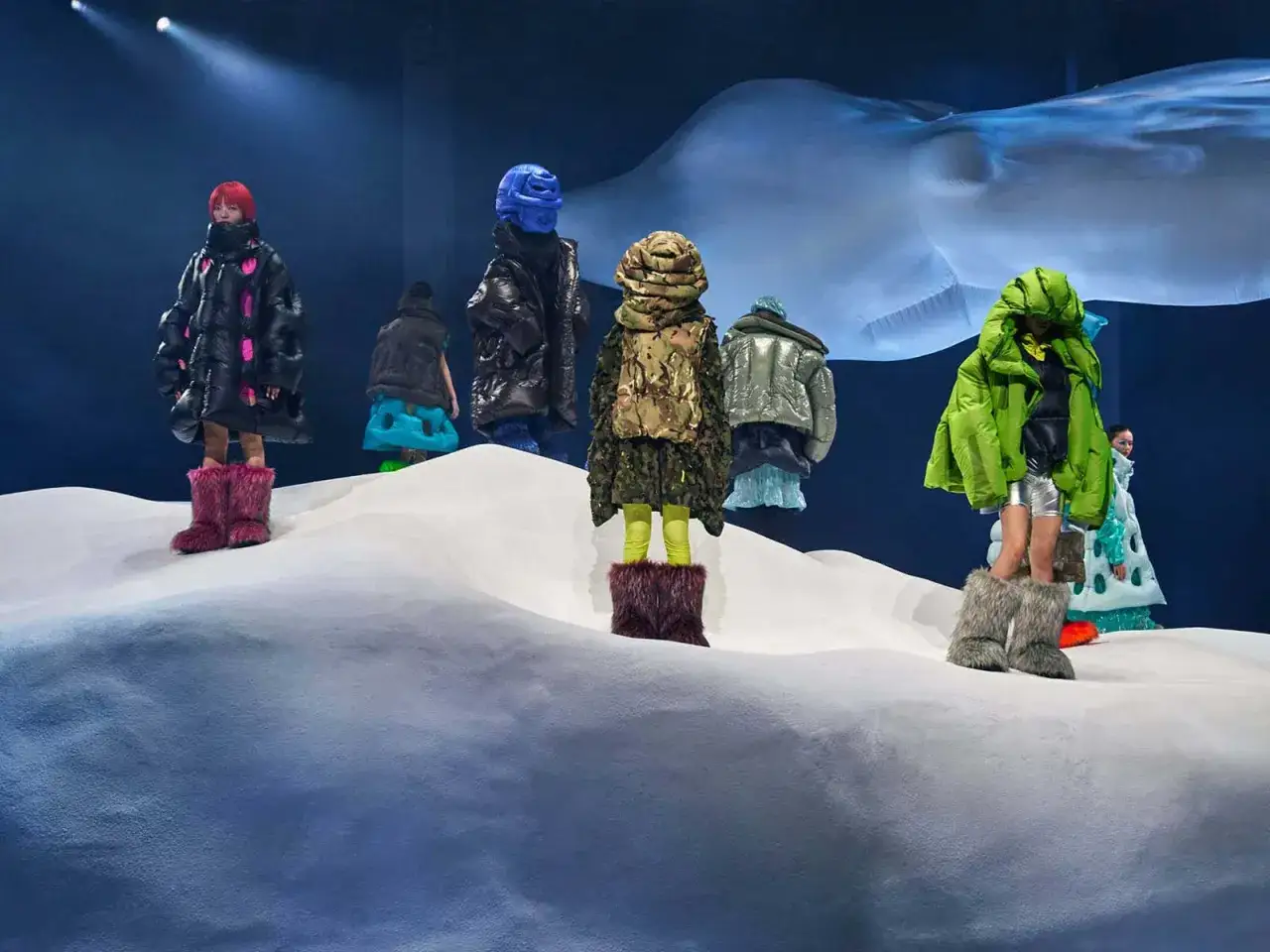 Dingyun Zhangs Models pr&auml;sentieren auf einer Schneelandschaft volumin&ouml;se, bunte Daunenjacken und auff&auml;llige Fellstiefel.