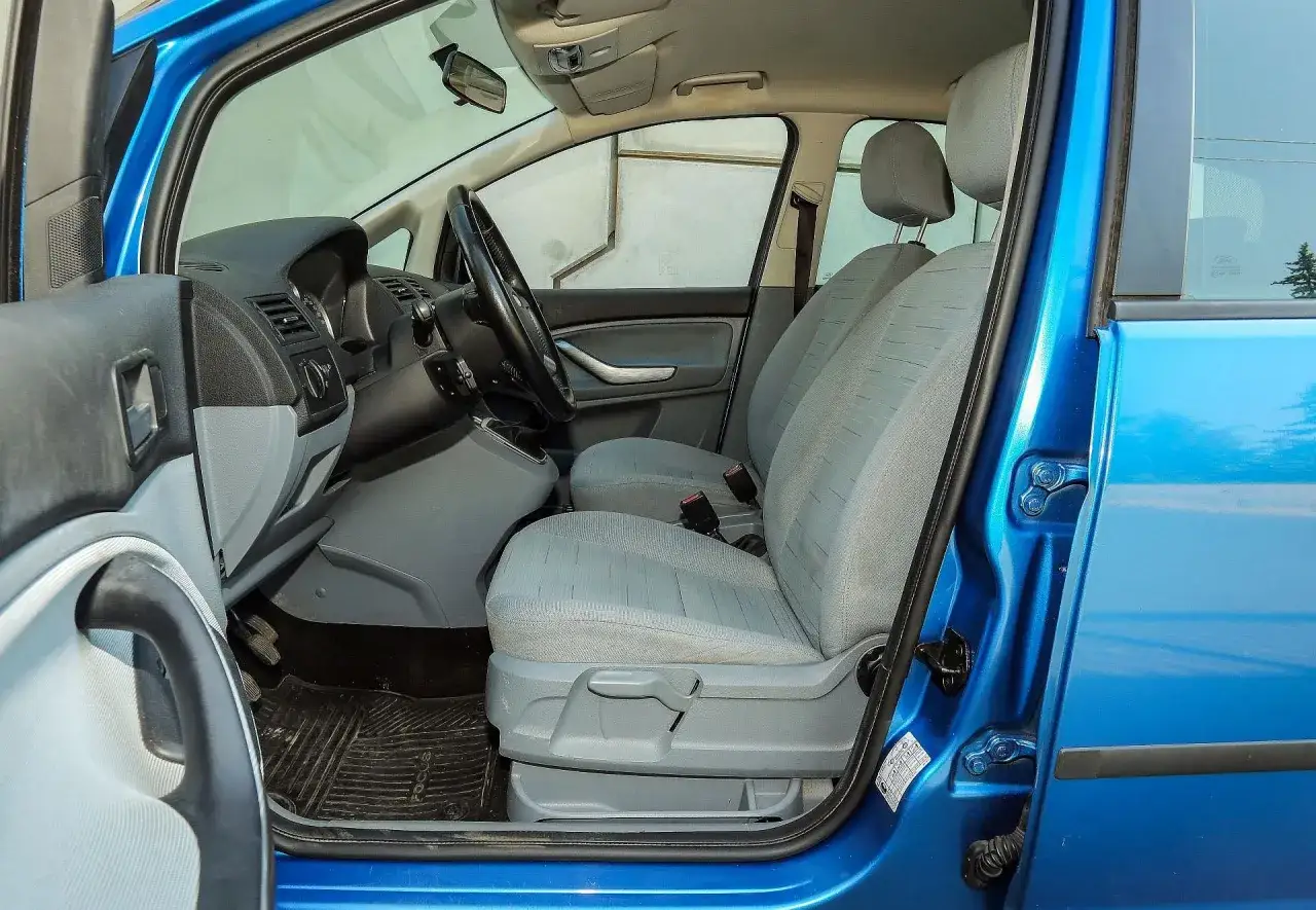 Wnętrze niebieskiego Ford Focus C-Max 2004: przednie fotele, deska rozdzielcza i kierownica.