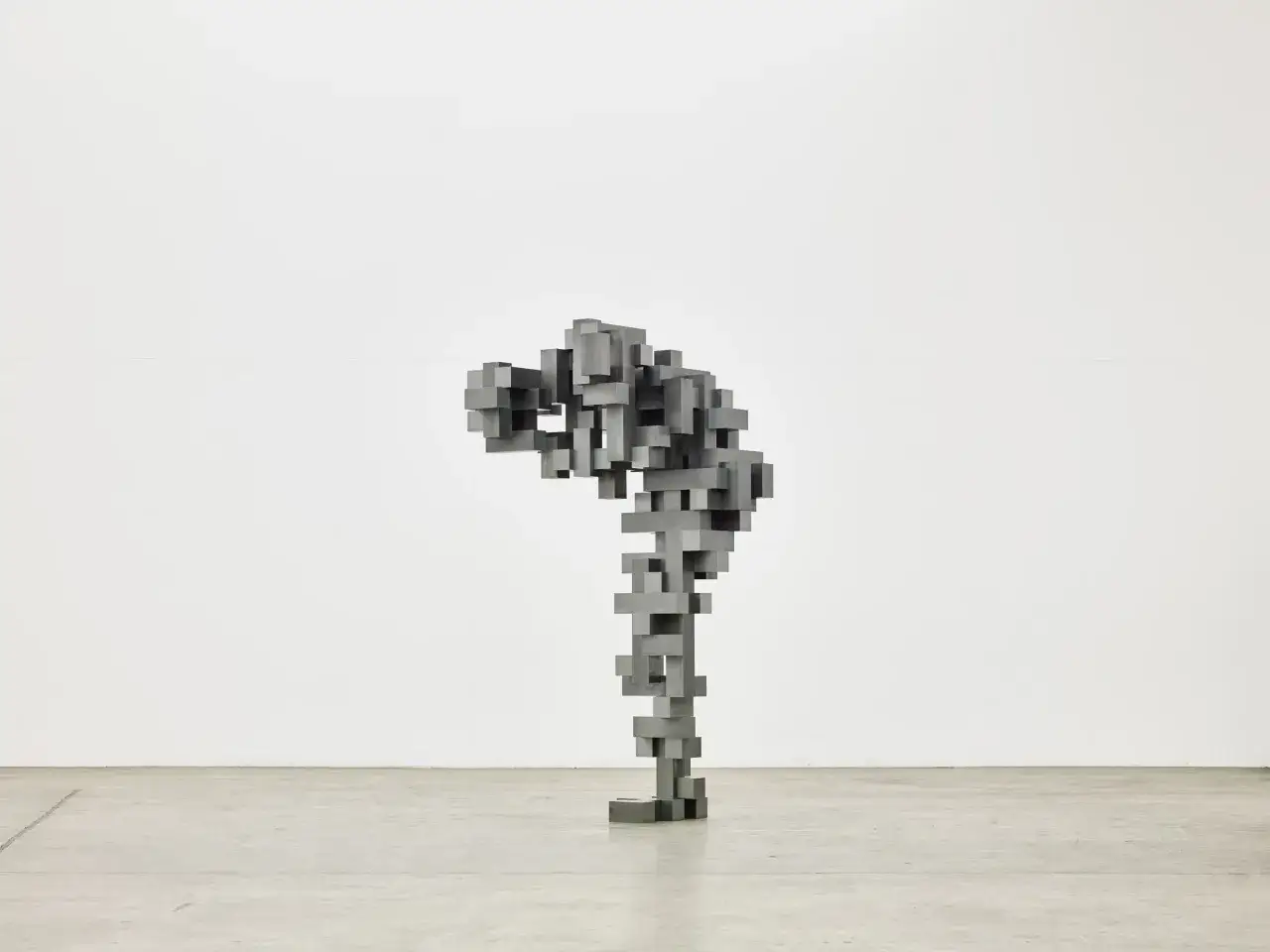 Sculpture abstraite en blocs de m&eacute;tal, &eacute;voquant une silhouette pench&eacute;e, dans le style d'Antony Gormley.