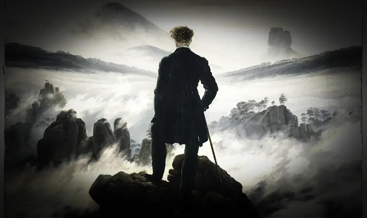 Uomo in piedi su una roccia, contemplando un paesaggio nebbioso. Un'immagine che evoca la **crisi di mezza età** e la ricerca di sé.