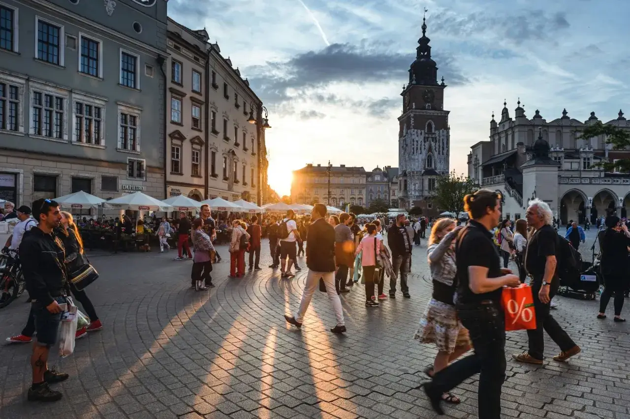 Tłum ludzi na Rynku Głównym w Krakowie, zachód słońca. Czy jest krakow safe? Tak, wygląda na to, że tak.