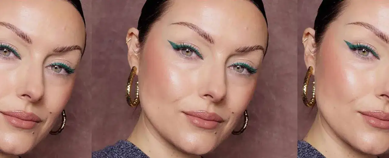 Occhio incappucciato con eyeliner verde smeraldo audace, labbra nude lucide e grandi orecchini a cerchio dorati.
