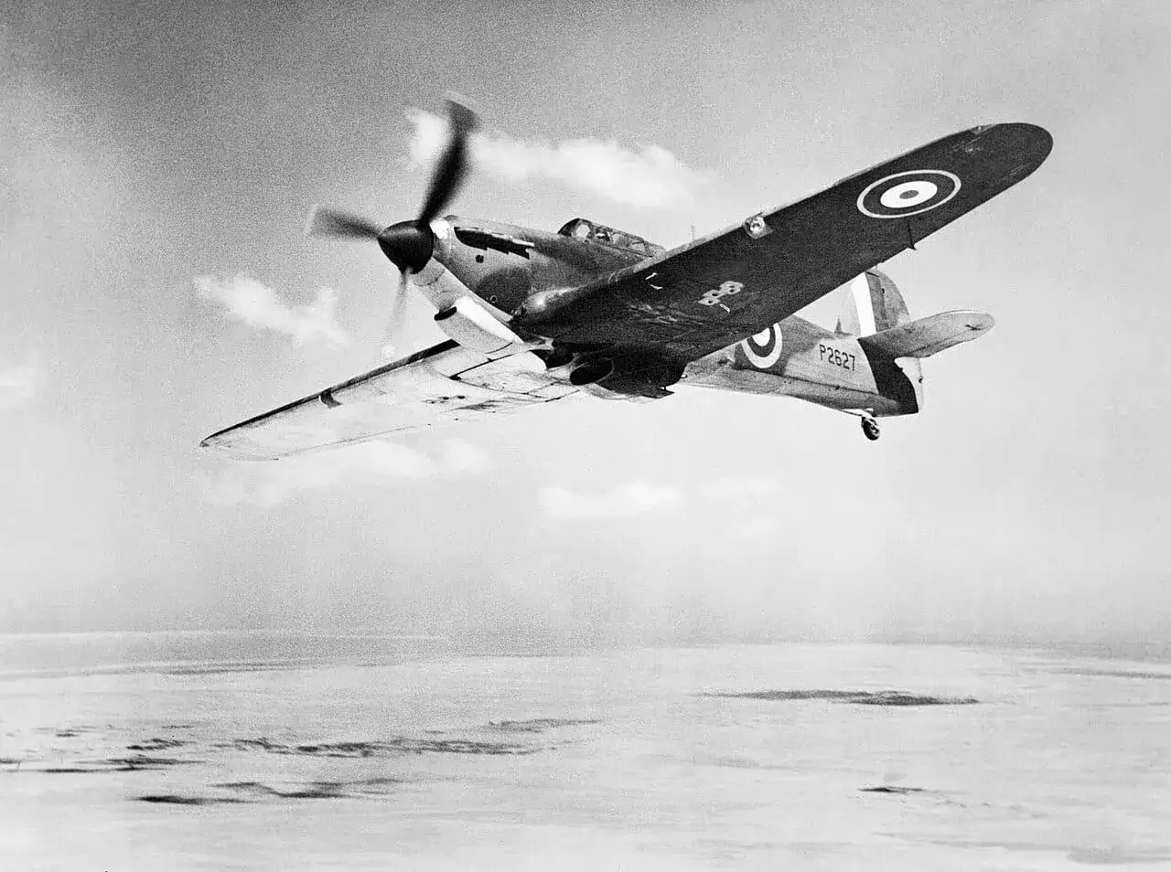 Ein Hurricane-Flugzeug fliegt &uuml;ber eine neblige Landschaft.