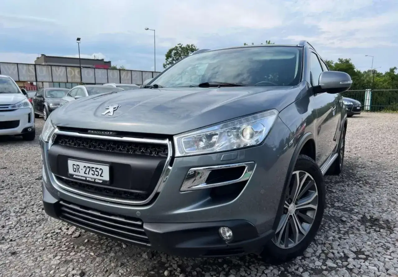 Szary Peugeot 4008 z tablicą GR-27552 stoi na parkingu wśród innych samochodów.