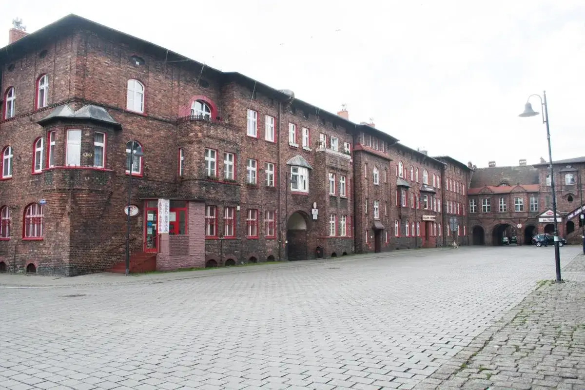 Charakterystyczne ceglane kamienice z czerwonymi ramami okien na Nikiszowcu w Katowicach.