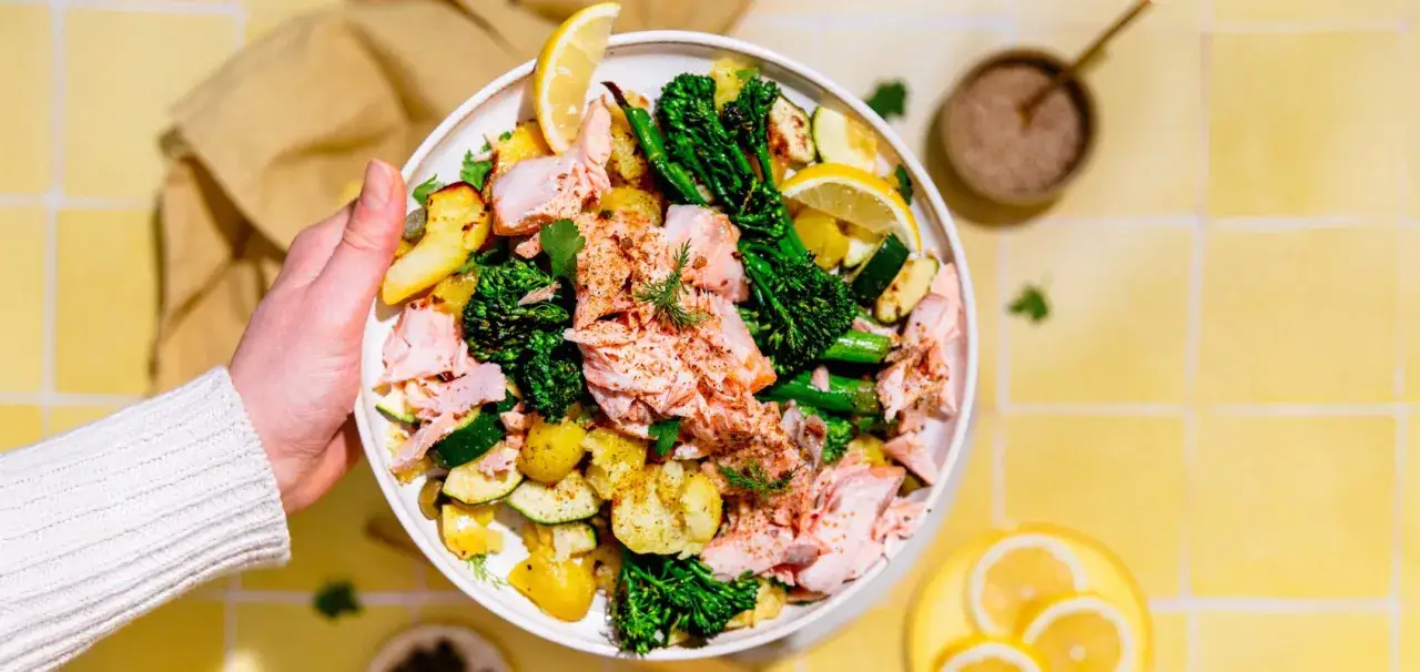 Teller mit Spargel, Lachs, Kartoffeln und Zucchini, garniert mit Zitrone und Dill.