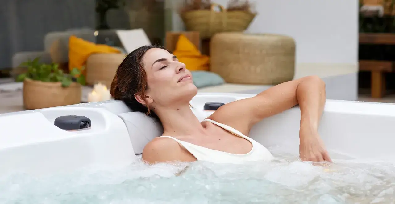 En kvinna njuter av ett avkopplande spa för gravida. Vattnet bubblar runt henne medan hon lutar sig tillbaka med slutna ögon.
