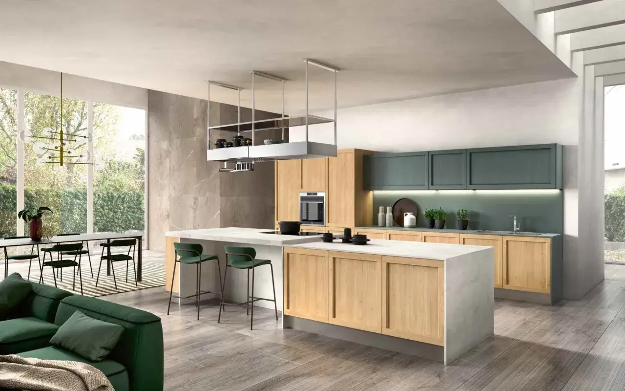 Cucina moderna con isola centrale in legno e marmo, pensili verdi e divano coordinato. Un'ispirazione per cambiare colore alla cucina.