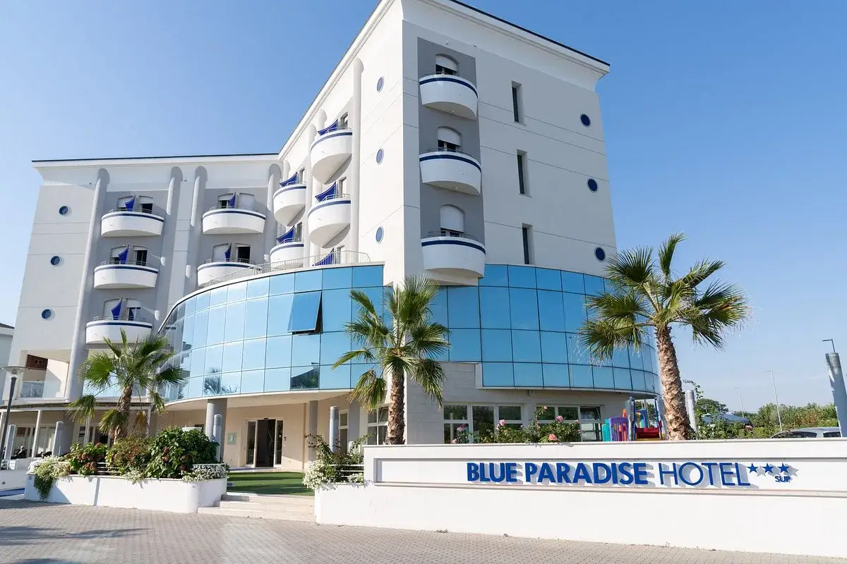 Hotel Blue Paradise a San Mauro Mare, con palme e un'architettura moderna.