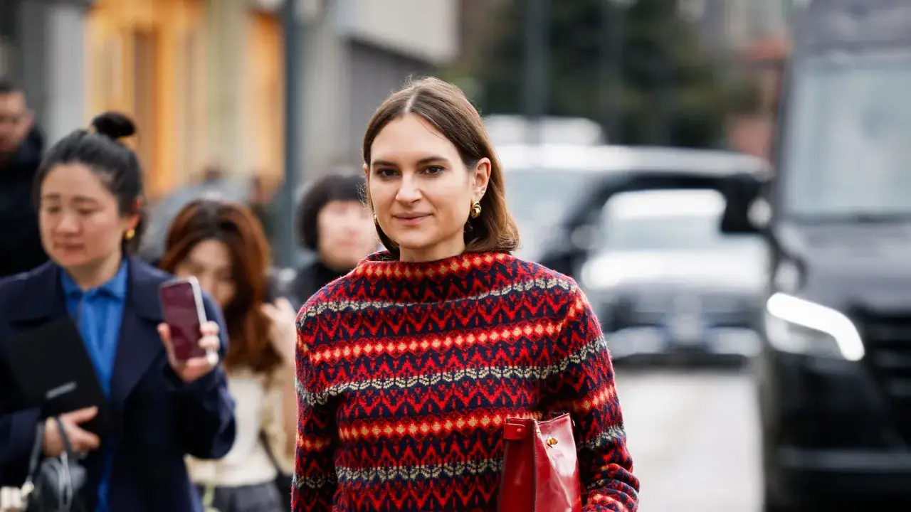 Mujer con jersey de rombos rojos y azules, mostrando que jerseys se llevan este año.