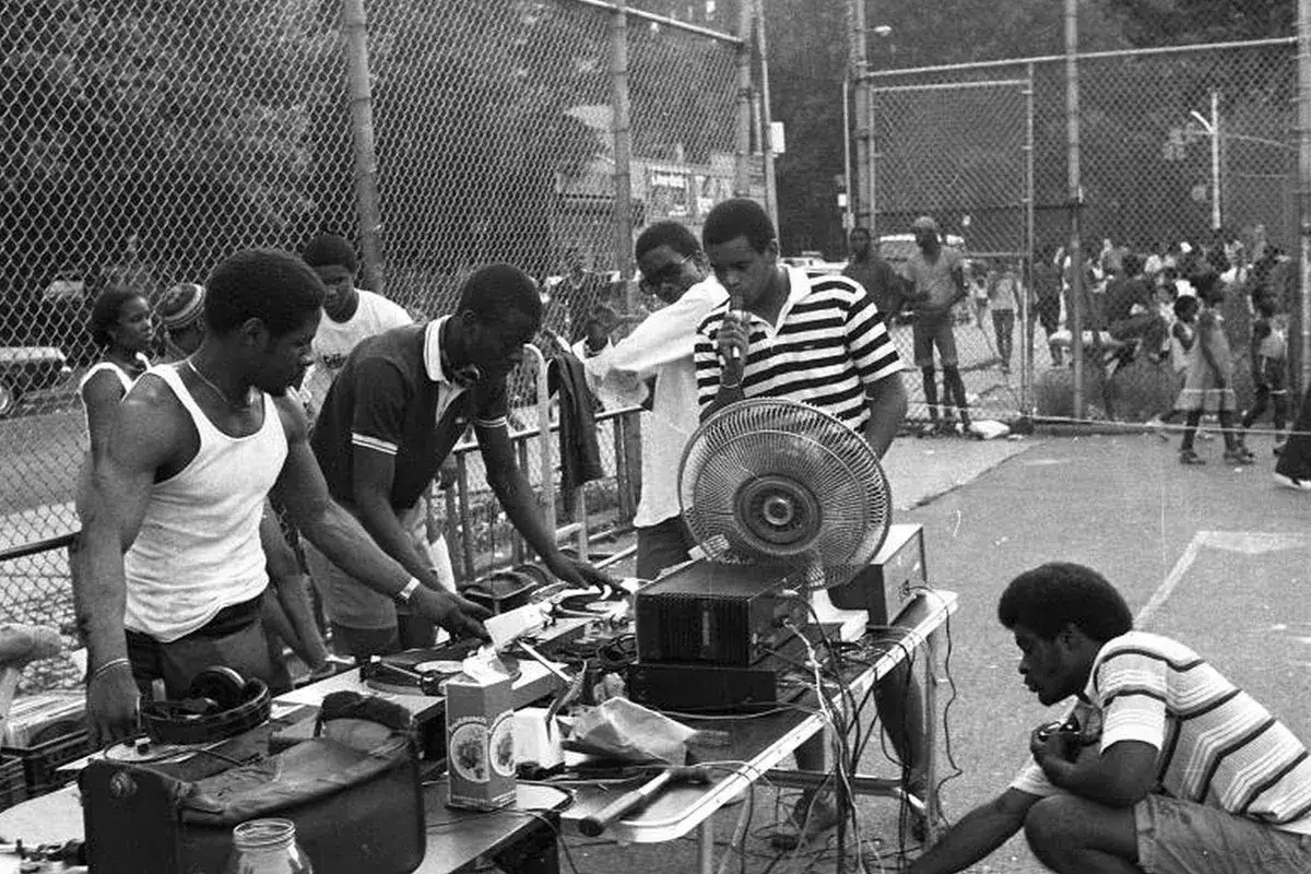 DJ's en acción, un momento clave en la historia del hip hop. Equipos de sonido, vinilos y la energía de la calle.