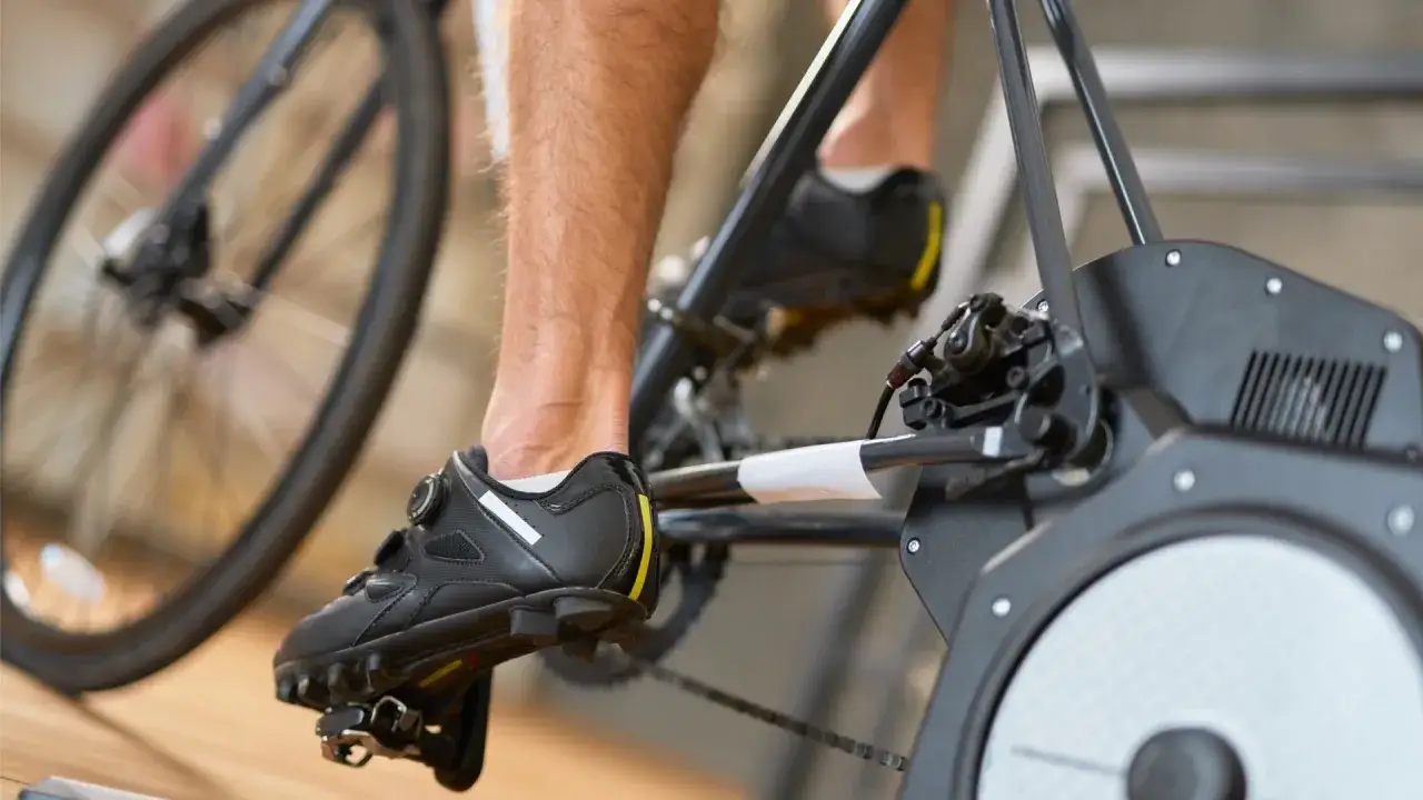 Close-up of a cyclist's shoe on a trainer, measuring average watts cycling.
