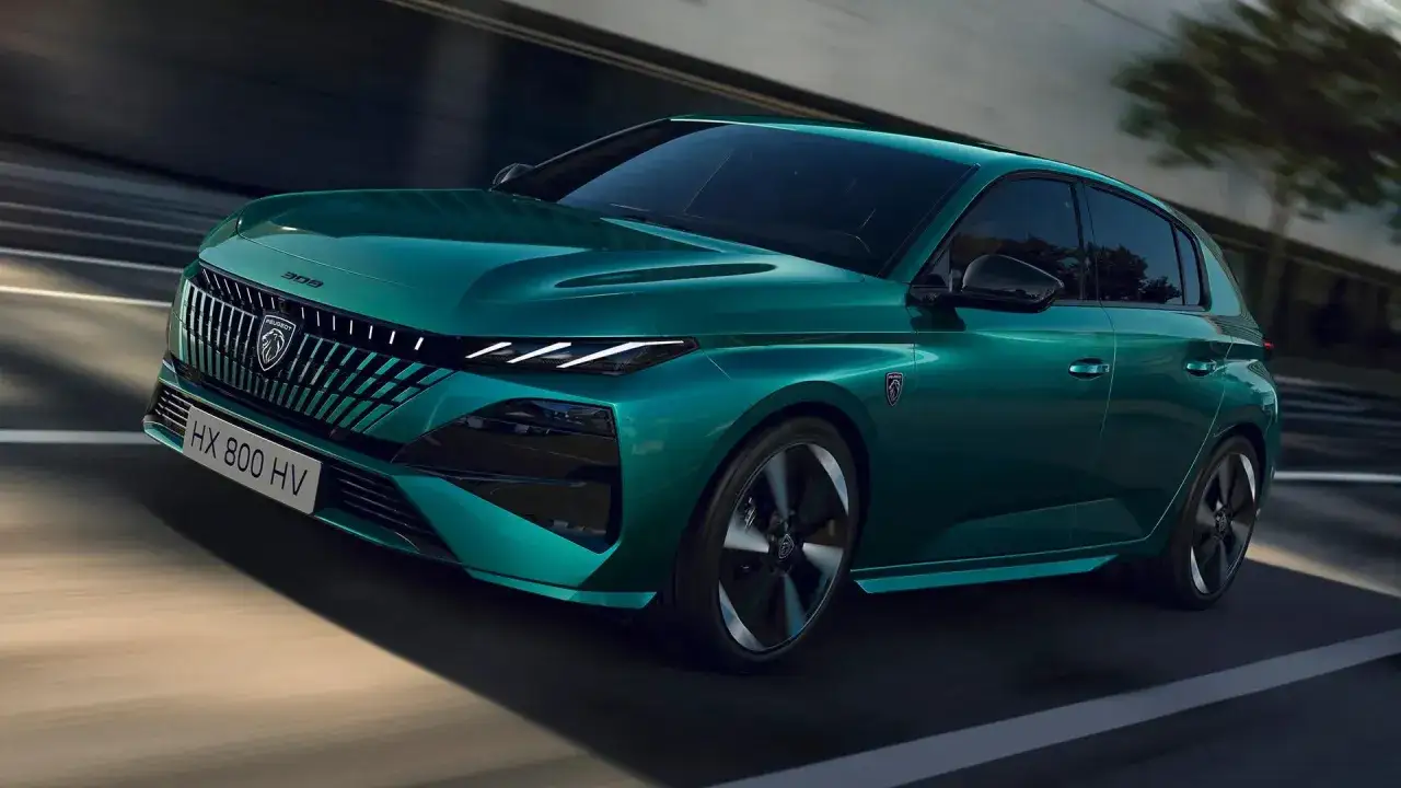 En gr&ouml;n fransk bil, en Peugeot 308, k&ouml;r p&aring; en v&auml;g.