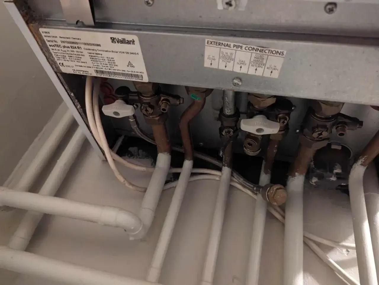 Zawory przy piecu Vaillant Ecotec Plus. Woda do pieca jest doprowadzana przez zawór z napisem 