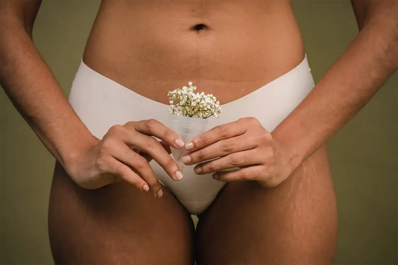 Delikatny bukiet kwiatów w kubeczku menstruacyjnym, symbolizujący, jak wygląda okres – naturalnie i pięknie.