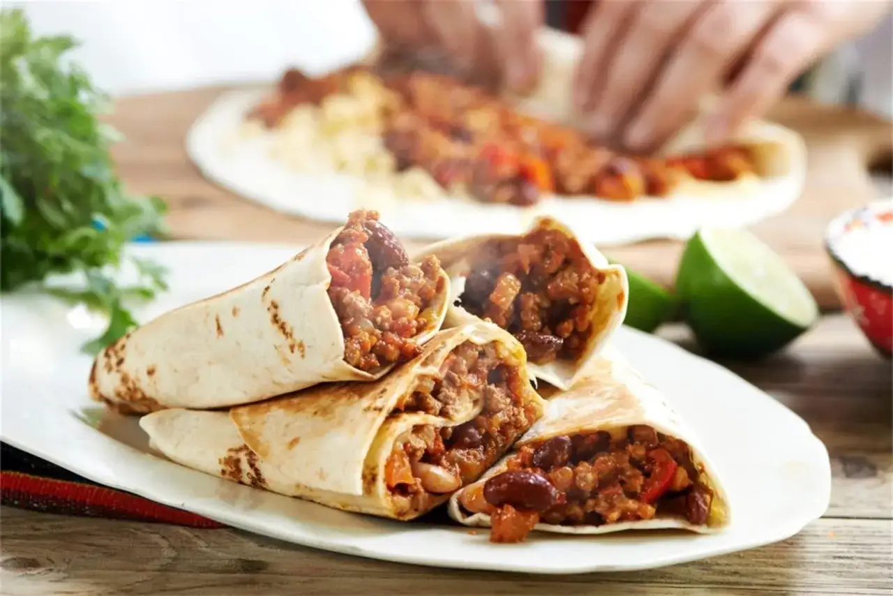 Gotowy burrito przepis na talerzu: sycące tortille z mielonym mięsem, fasolą i warzywami.