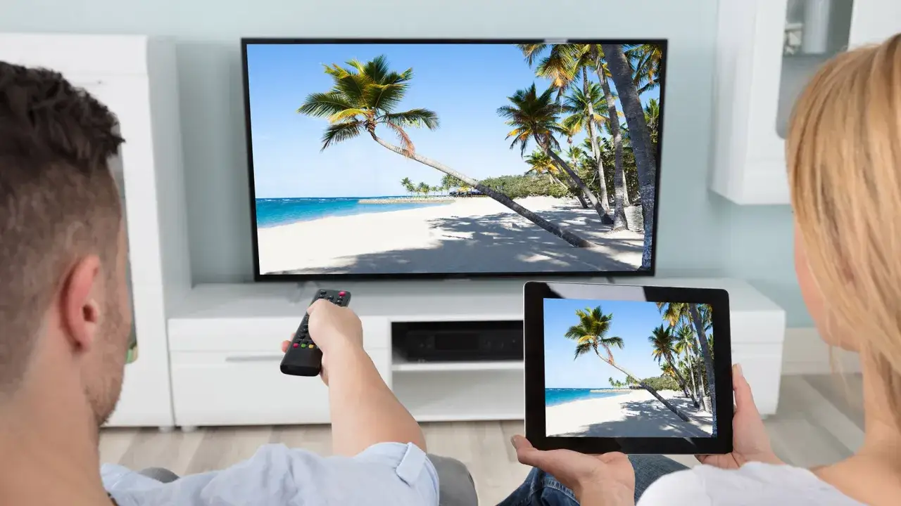 Para zrelaksowana, ogląda ten sam tropikalny widok na telewizorze i tablecie. Dowiedz się, jak zduplikować ekran, aby cieszyć się treścią na większym wyświetlaczu.