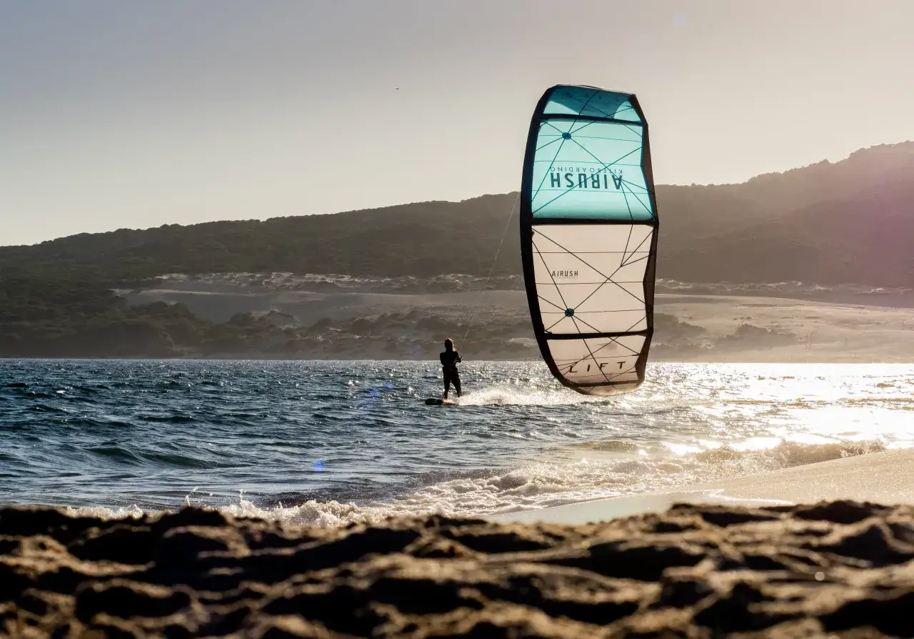 Kitesurferka bez wysiłku na wodzie, zach&oacute;d słońca