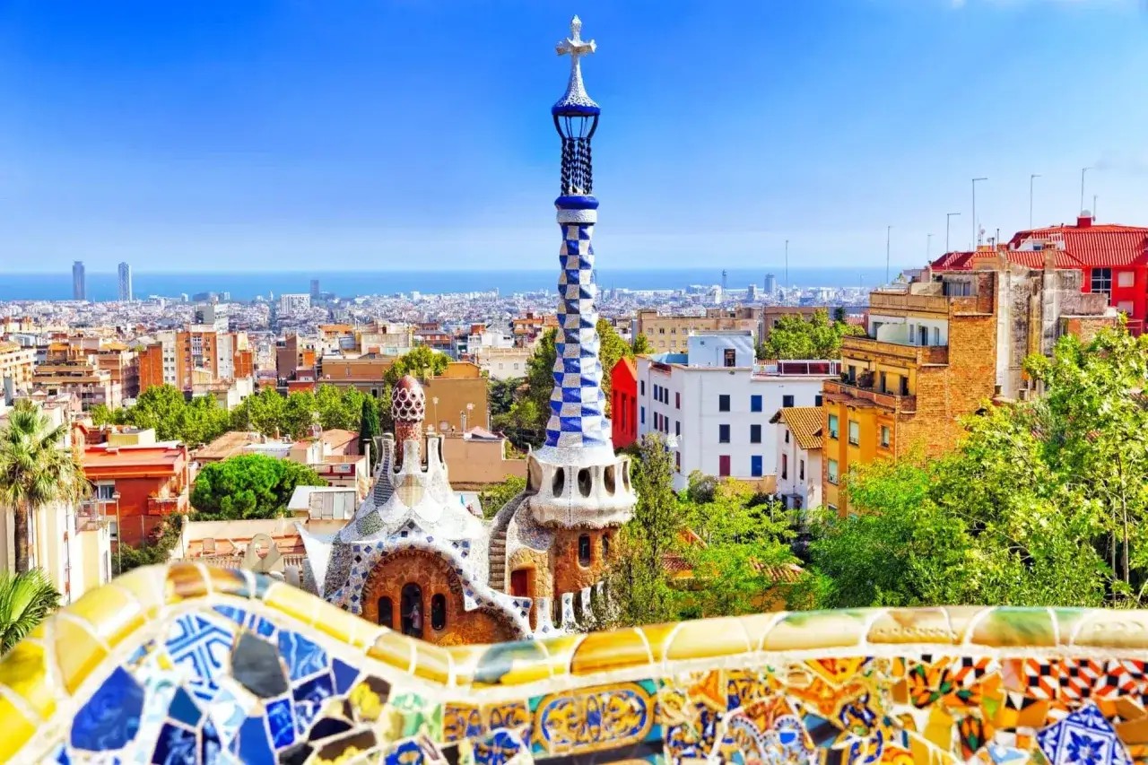 Kolorowe mozaiki i fantazyjne budowle w Ogrodach Gaudiego, z widokiem na Barcelonę. Warto kupić **ogrody gaudiego bilety** online.