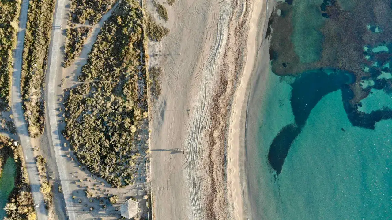 Vista a&eacute;rea de una playa virgen con arena dorada, vegetaci&oacute;n &aacute;rida y aguas cristalinas. &iquest;Ser&aacute; esta la mejor playa de Roquetas de Mar?
