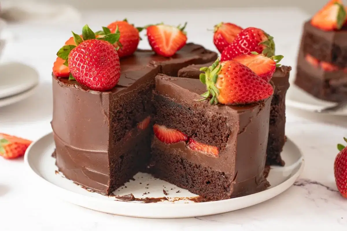 Deliciosa tarta de fresas y chocolate, cubierta de ganache y decorada con fresas frescas. Un postre irresistible.