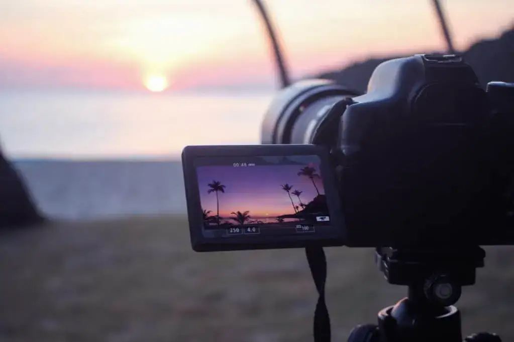 close-up of a camera's flip-out vari-angle screen showing a person vlogging