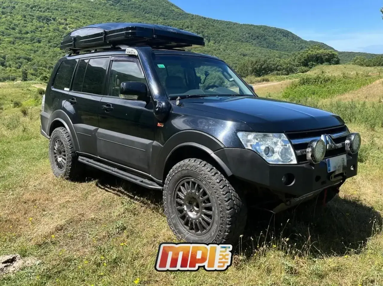 Mitsubishi Montero V80 preparado para aventura, con techo solar y llantas todoterreno, listo para explorar montañas.