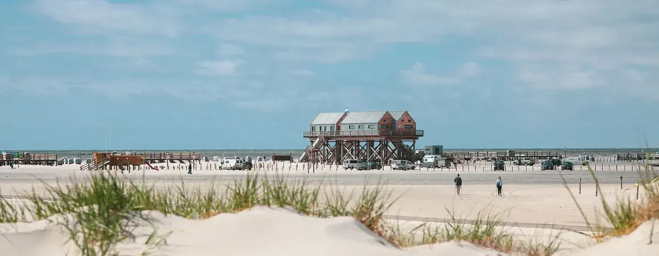St. Peter-Ording Strand mit Stelzenh&auml;usern, Strandk&ouml;rben und dem weiten Blick auf die Nordsee.