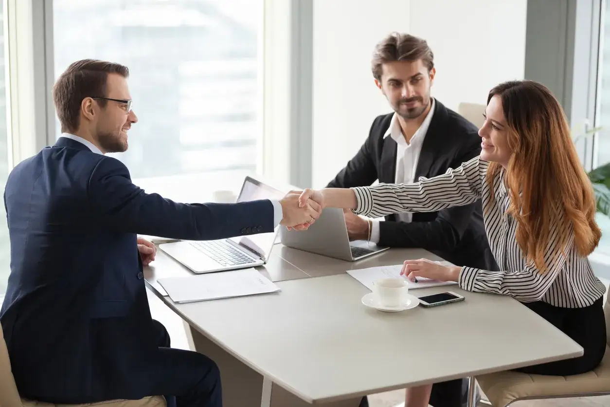 Un uomo e una donna si stringono la mano, un accordo che definisce l'employer branding cos'&egrave;.