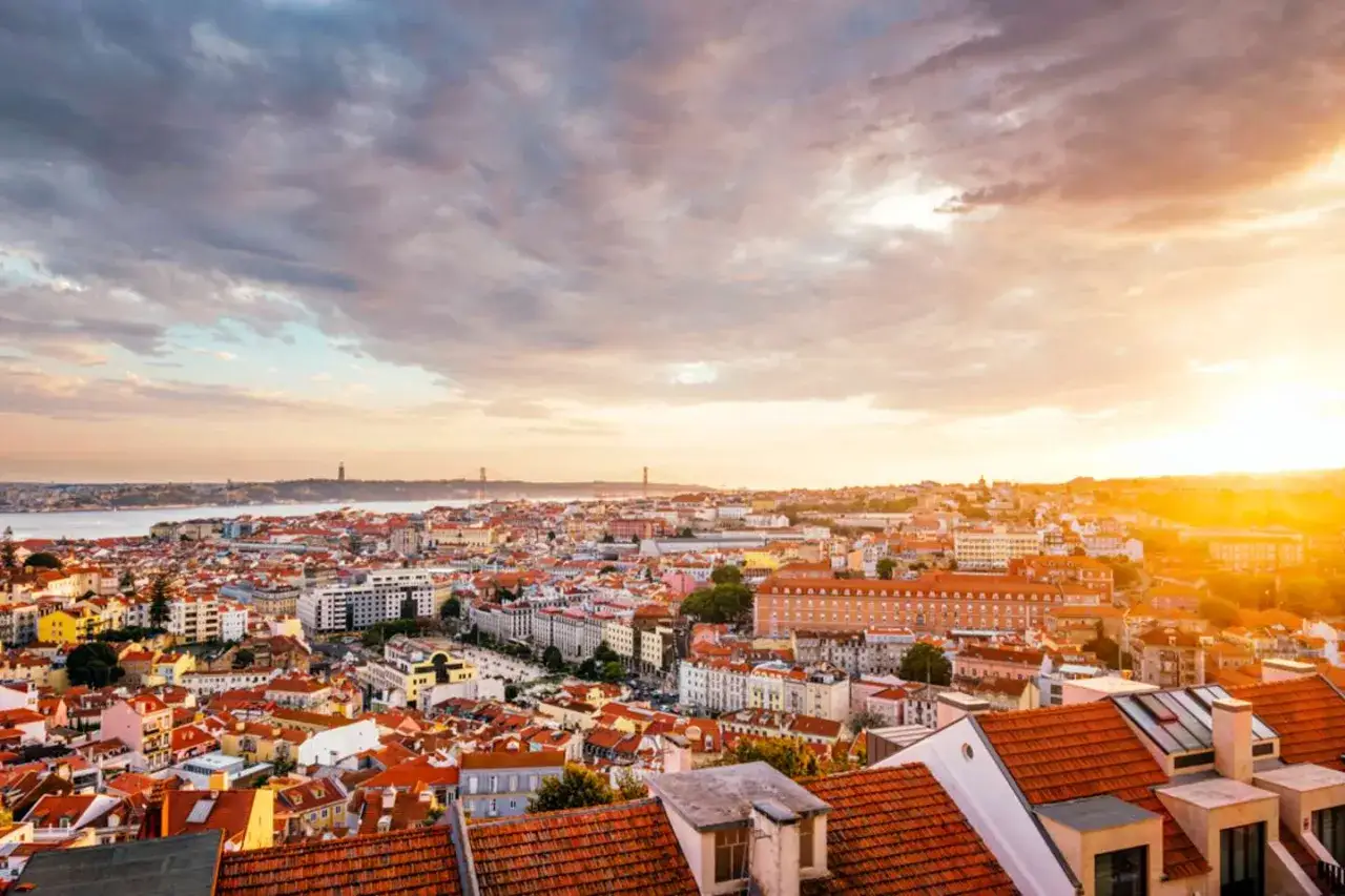 Sonnenuntergang &uuml;ber Lissabon. Die perfekte Lissabon Reisezeit f&uuml;r malerische Ausblicke auf die Stadt und den Tejo.