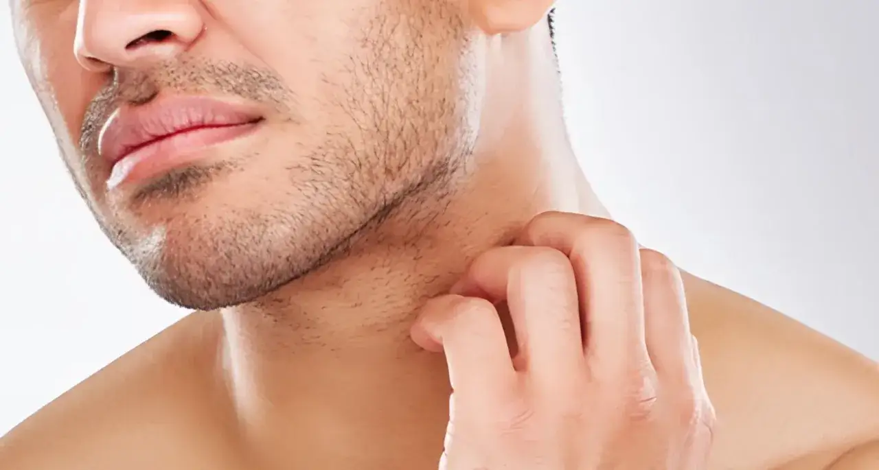 Hombre se rasca la barba incipiente, buscando un afeitado perfecto.