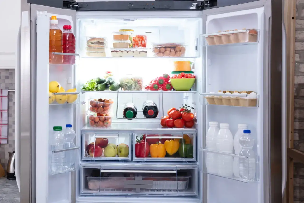 Un frigo qui givre, mais plein de bonnes choses : fruits, légumes, œufs, boissons et même des burgers.