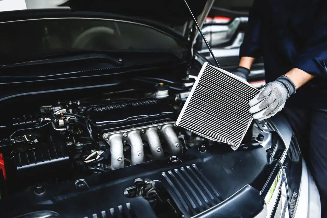 Mechaniker h&auml;lt einen neuen Luftfilter bereit, um den alten im Auto zu ersetzen. Regelm&auml;&szlig;iges luftfilter reinigen sorgt f&uuml;r optimale Motorleistung.