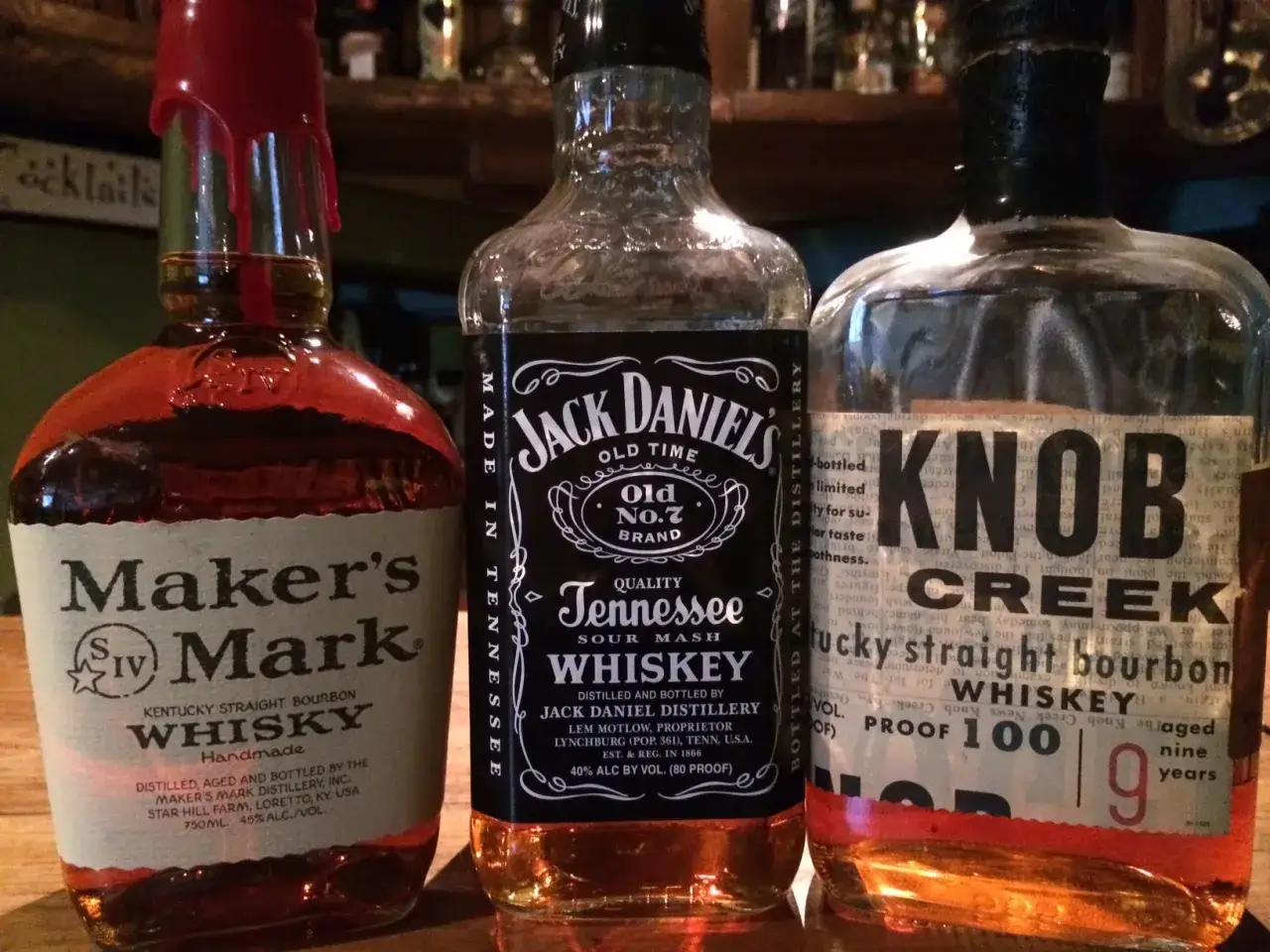 Trzy butelki whisky: Maker's Mark, Jack Daniel's i Knob Creek.