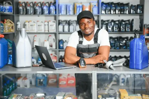 personne comparant des pièces auto sur un ordinateur et dans un magasin